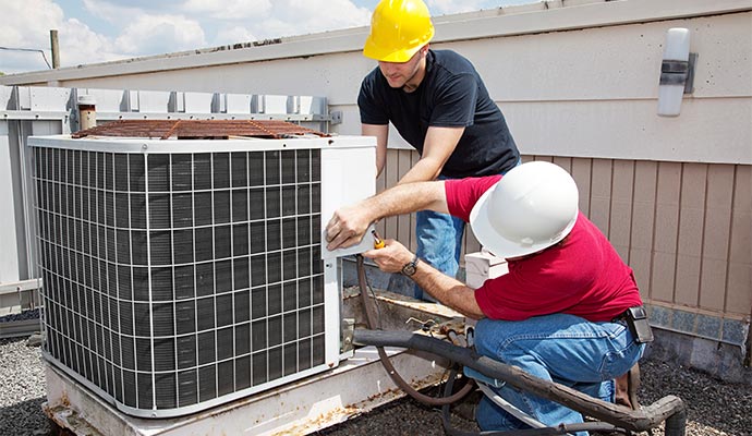 men repairing ac unit on the rooftop