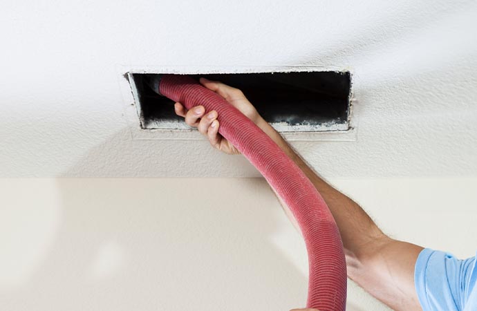 Worker cleaning ducts.